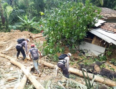 Anggota Brimob Kompi 4 Batalyon B Pelopor Cipanas membersihkan jalan tertutup longsor di Kampung Munjul, Desa Karangnunggal, Kecamatan Cibeber, Kabupaten Cianjur, Senin (23/03/2020).