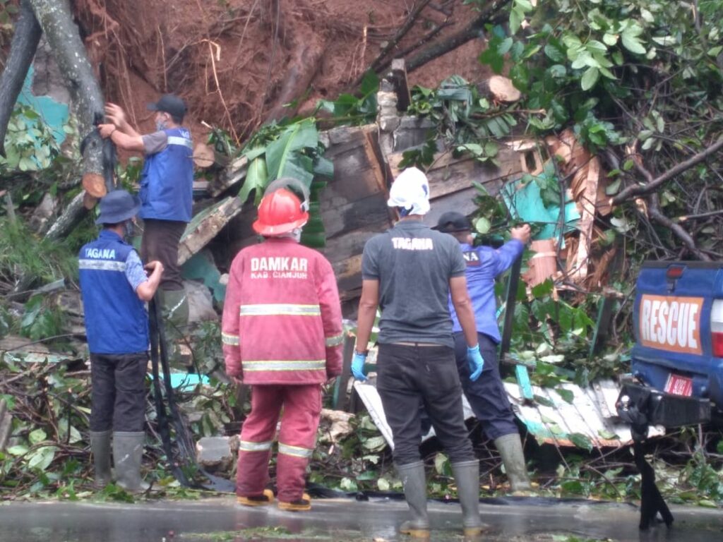 MEMBERSIHKAN: Petugas gabungan tengah membersihkan material longsor di Kampung Ciwareugu RT 02/RW 07, Desa Mekargalih, Kecamatan Cikalongkulon. (Foto: Rendi Irawan/cianjurupdate.com)