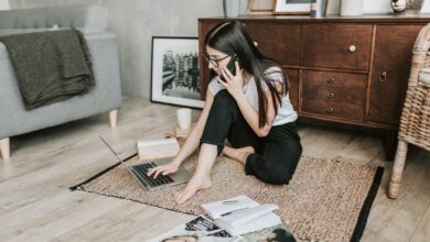 Woman Using Her laptop While Having A Conversation Over The Phone