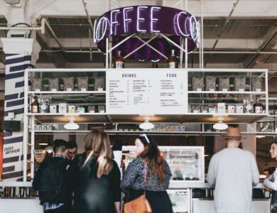 group of people standing in front of food stall counter