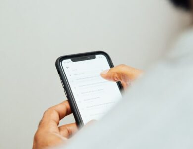 man in white top holding iPhone