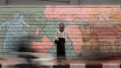 woman standing against mural wall