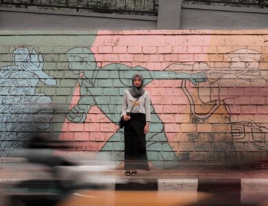 woman standing against mural wall