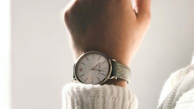 person wearing round silver-colored analog watch