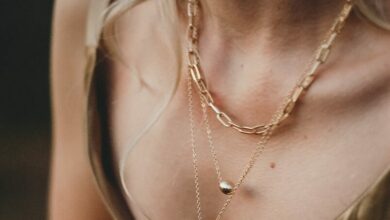 woman in gold sleeveless dress wearing gold necklace