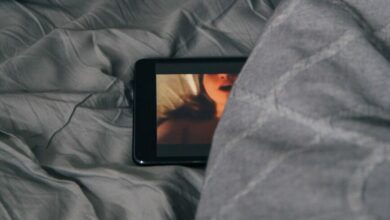 black Android smartphone on gray bed sheet