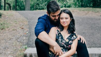 man wearing blue dress shirt and black pants and woman in black floral dress