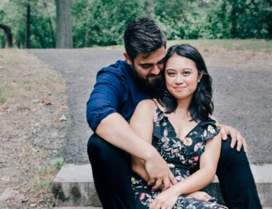 man wearing blue dress shirt and black pants and woman in black floral dress