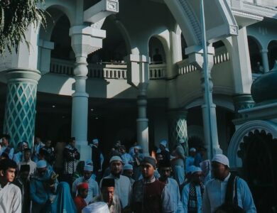 white concrete building near green trees under blue sky during daytime
