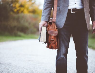 man holding book on road during daytime