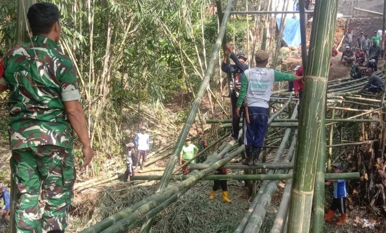 Koramil Cipanas membangun jembatan darurat bambu di Desa Ciwalen pasca jembatan putus akibat banjir.