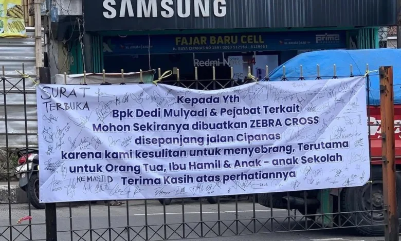 Warga Cipanas, Cianjur, mengeluhkan sulitnya menyeberang jalan di Jalur Puncak dekat pasar. Petisi zebra cross via spanduk dipasang.