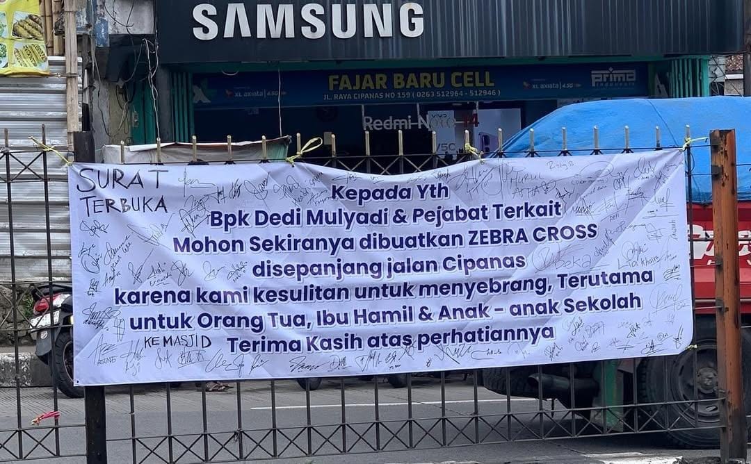 Warga Cipanas, Cianjur, mengeluhkan sulitnya menyeberang jalan di Jalur Puncak dekat pasar. Petisi zebra cross via spanduk dipasang.