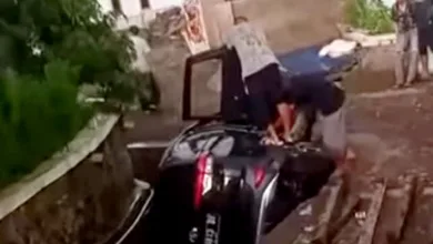 Sebuah mobil SUV hitam terperosok ke parit di Cugenang, Cianjur, diduga karena pengemudi mengantuk saat hendak parkir.