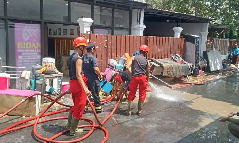 Banjir di Cianjur mulai surut. Warga bersama petugas gotong royong membersihkan sisa lumpur dan material.