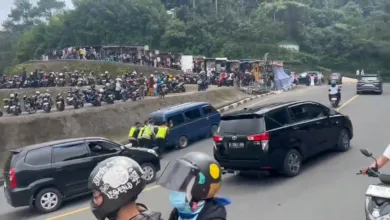 Sebuah mobil gagal menanjak di Jalur Puncak Bogor saat one way. Enam polisi sigap membantu mendorong hingga mobil kembali berjalan.