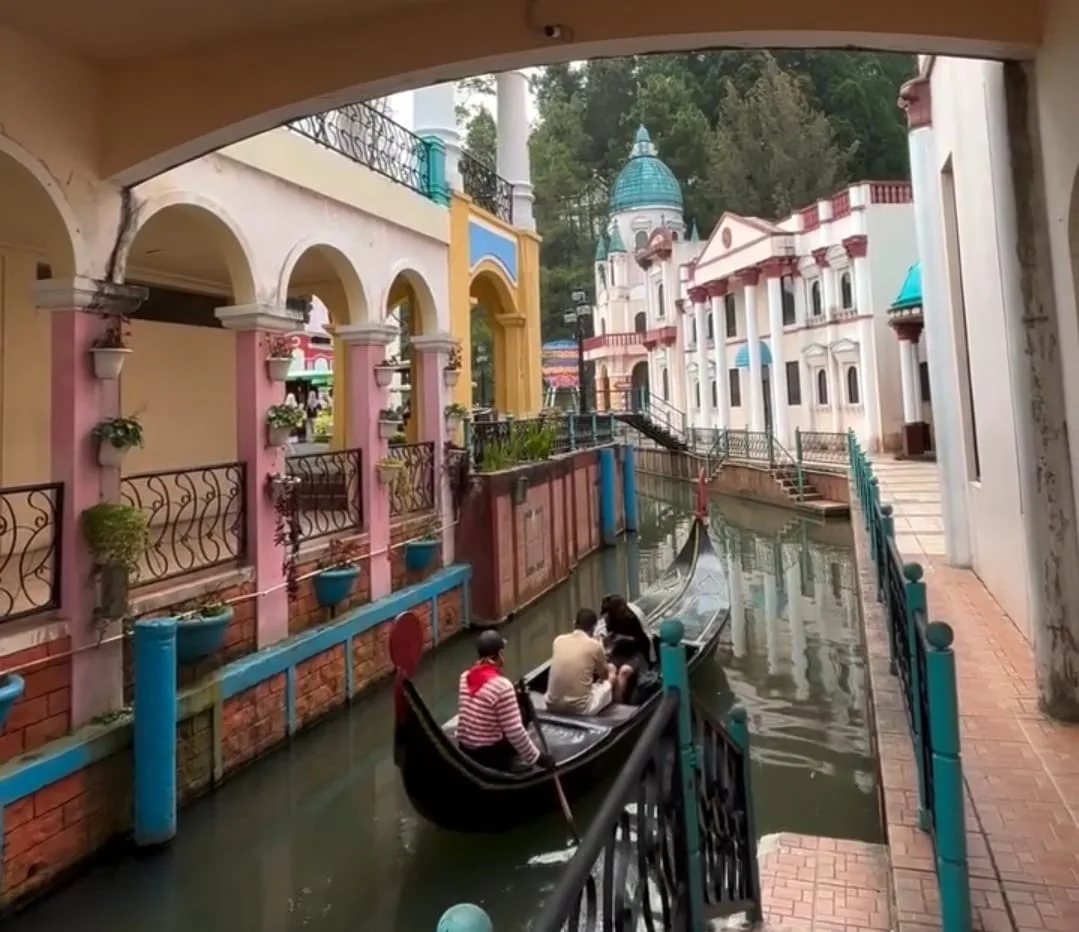 Pengunjung menikmati sensasi menaiki perahu gondola di kanal buatan Little Venice, Kota Bunga, Cianjur, yang didesain menyerupai arsitektur kota Venesia, Italia.