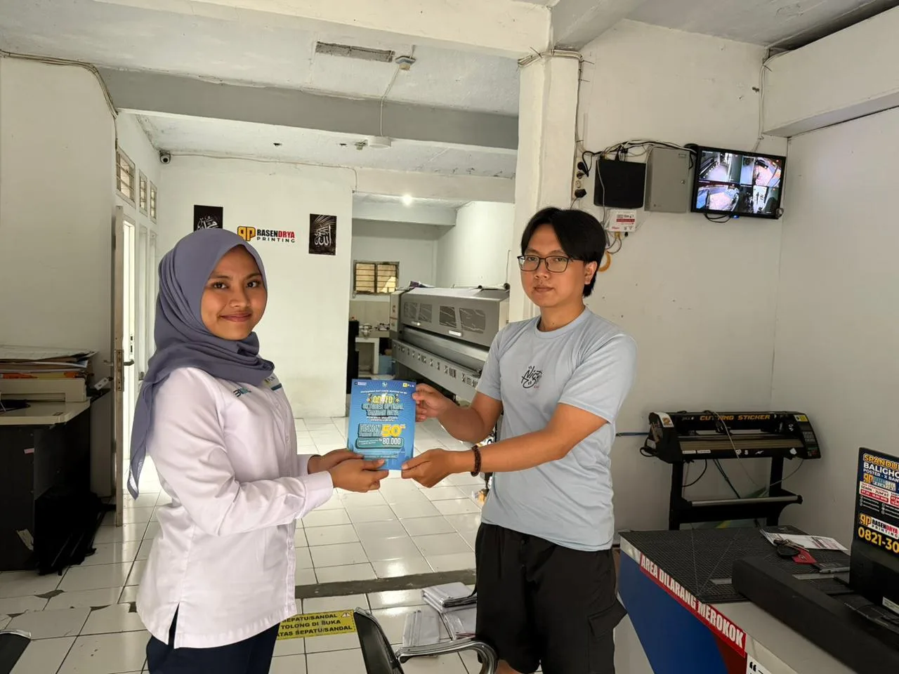 Srikandi PLN (kiri) saat berinteraksi dengan salah satu pelanggan. Semangat Sumpah Pemuda diwujudkan melalui pelayanan dan kerja nyata insan PLN untuk menerangi masyarakat, seperti dedikasi Aulia Paramitha di ujung selatan Cianjur.