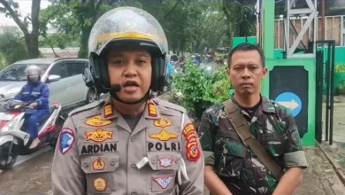 Kasatlantas Polres Cianjur, AKP M. Hardian Andrianto, didampingi anggota TNI, memberikan keterangan di lokasi kejadian pohon tumbang di Jalan Raya Bandung.