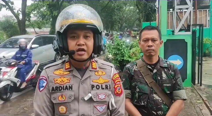 Kasatlantas Polres Cianjur, AKP M. Hardian Andrianto, didampingi anggota TNI, memberikan keterangan di lokasi kejadian pohon tumbang di Jalan Raya Bandung.