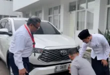 Bupati Cianjur dr. Mohammad Wahyu Ferdian (kanan) mengamati petugas Dishub (jongkok) saat memasang stiker program parkir berlangganan pada kendaraannya