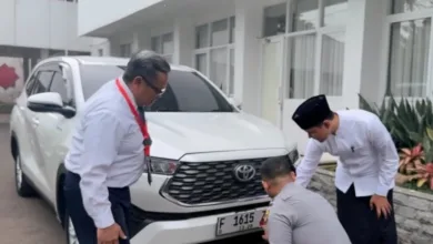 Bupati Cianjur dr. Mohammad Wahyu Ferdian (kanan) mengamati petugas Dishub (jongkok) saat memasang stiker program parkir berlangganan pada kendaraannya