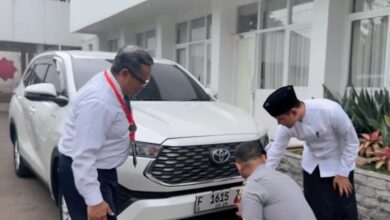 Bupati Cianjur dr. Mohammad Wahyu Ferdian (kanan) mengamati petugas Dishub (jongkok) saat memasang stiker program parkir berlangganan pada kendaraannya