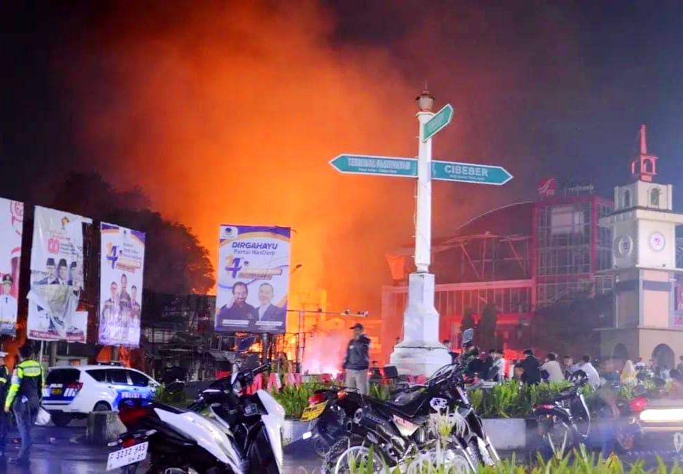 Api membubung tinggi di atas bangunan dan area sekitar pasca-insiden terbakarnya sebuah truk tangki BBM di Jalan Perintis Kemerdekaan, Kecamatan Cilaku, Cianjur.