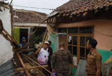 Aparat kelurahan (kanan) bersama warga memeriksa puing-puing bangunan rumah yang rusak berat akibat terjangan angin kencang di Kelurahan Sayang, Kecamatan Cianjur, Senin (3/11/2025).