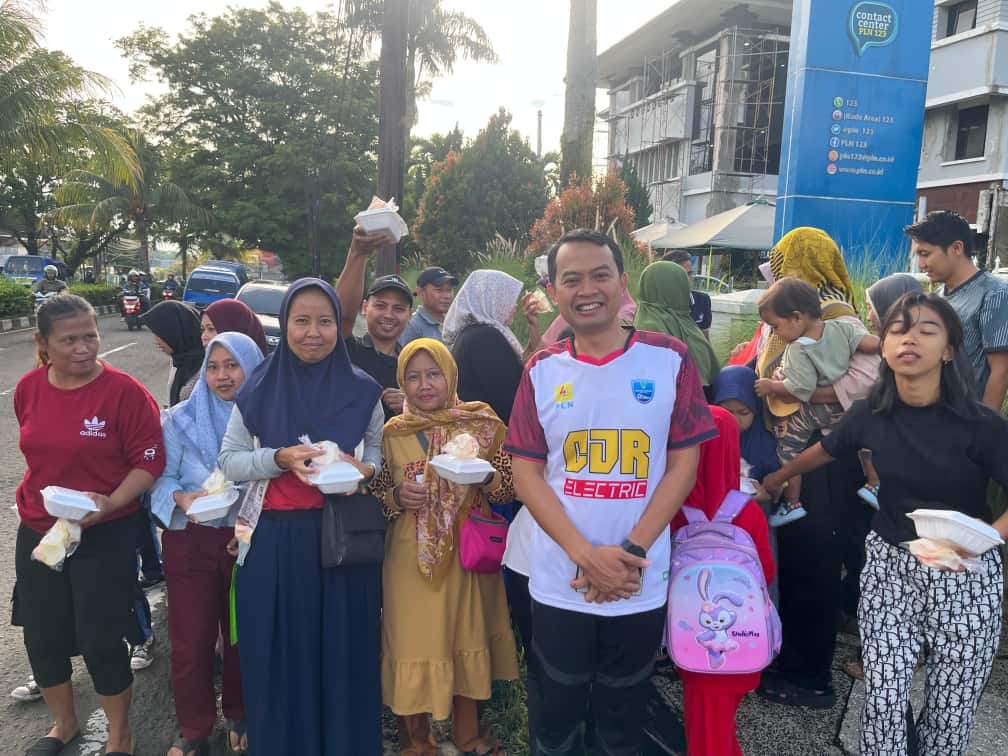 Manager PLN UP3 Cianjur, Andre Pratama Djatmiko (tengah), berfoto bersama warga sekitar yang menerima paket sarapan gratis di depan kantor PLN UP3 Cianjur. Aksi sosial ini digelar sebagai wujud kepedulian dan semangat berbagi di momen Hari Pahlawan.