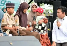 Bupati Cianjur, dr. Wahyu (kanan), berdialog dengan Alif dan Kanaya saat mengumumkan pengangkatan mereka sebagai anak asuh di acara Rembug Warga, Sukaluyu.