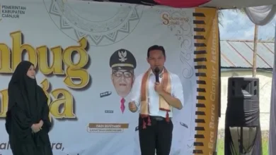 Bupati Cianjur, dr. Wahyu Ferdian (kanan), didampingi Ketua TP PKK Kabupaten Cianjur, dr. Najmah Nur Islami (kiri), memberikan sambutan pada kegiatan Rembug Warga di Desa Sukawangi, Kecamatan Warungkondang, Jumat (21/11/2025).