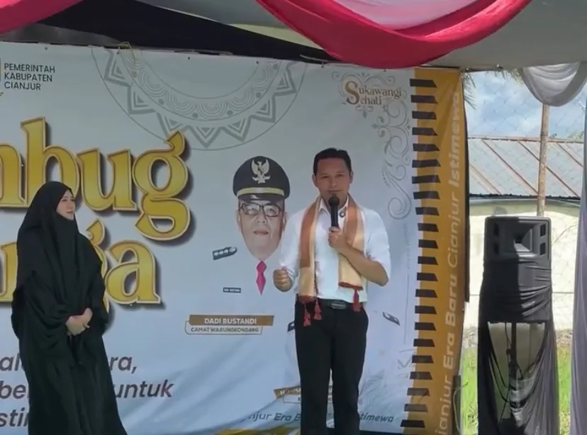 Bupati Cianjur, dr. Wahyu Ferdian (kanan), didampingi Ketua TP PKK Kabupaten Cianjur, dr. Najmah Nur Islami (kiri), memberikan sambutan pada kegiatan Rembug Warga di Desa Sukawangi, Kecamatan Warungkondang, Jumat (21/11/2025).