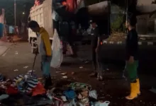 Sejumlah petugas kebersihan berjibaku mengangkut tumpukan sampah dari TPS sementara ke dalam truk pada malam hari di Cianjur.