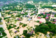 KEPUNGAN BANJIR: Tangkapan layar udara menunjukkan luasnya area permukiman yang tenggelam oleh banjir besar, menyisakan atap rumah dan pepohonan di tengah genangan air bah. (Foto: Instagram btgfeed)
