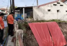 Jajaran BPBD mengamati area longsoran sayap Jembatan Cianjur Girang yang telah ditutup terpal sebagai penanganan darurat pasca-cuaca ekstrem, Senin (24/11).