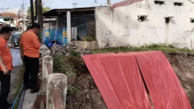 Jajaran BPBD mengamati area longsoran sayap Jembatan Cianjur Girang yang telah ditutup terpal sebagai penanganan darurat pasca-cuaca ekstrem, Senin (24/11).