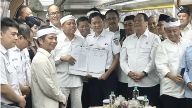 Gubernur Jawa Barat Dedi Mulyadi (kiri) bersama Direktur Utama PT KAI Bobby Rasyidin (tengah) memperlihatkan dokumen Perjanjian Kerja Sama usai penandatanganan di dalam kereta inspeksi, Selasa (25/11/2025).