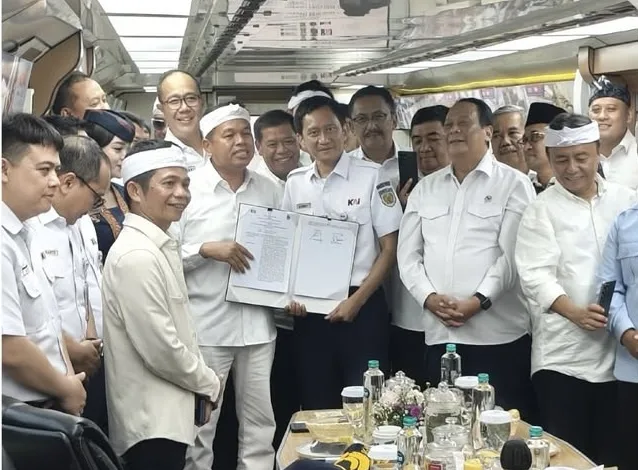 Gubernur Jawa Barat Dedi Mulyadi (kiri) bersama Direktur Utama PT KAI Bobby Rasyidin (tengah) memperlihatkan dokumen Perjanjian Kerja Sama usai penandatanganan di dalam kereta inspeksi, Selasa (25/11/2025).