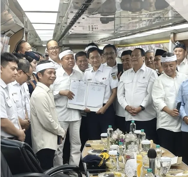 Gubernur Jawa Barat Dedi Mulyadi (kiri) bersama Direktur Utama PT KAI Bobby Rasyidin (tengah) memperlihatkan dokumen Perjanjian Kerja Sama usai penandatanganan di dalam kereta inspeksi, Selasa (25/11/2025).