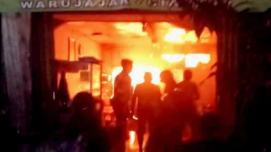 Api berkobar di Warung Nasi Ma Titing, Warujajar. Petugas dan warga terlihat di lokasi kejadian saat kebakaran terjadi pada malam hari.