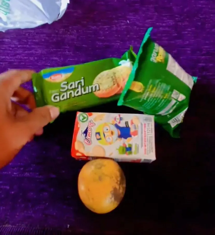 Tampilan menu program Makan Bergizi Gratis (MBG) di Desa Kubang yang dikeluhkan orang tua siswa. Selain didominasi makanan ringan kemasan, kondisi fisik buah jeruk yang disertakan terlihat tidak segar dan dinilai kurang layak diberikan kepada siswa.