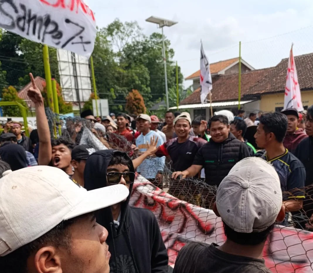 Ratusan warga Desa Langensari, Kecamatan Karangtengah, Kabupaten Cianjur, menggelar aksi unjuk rasa di depan Kantor Desa Langensari, Selasa (30/12/2025).