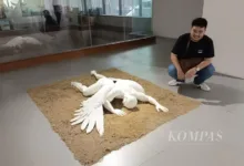 Seniman Alexander Chris asal Cianjur, Jawa Barat, dengan karya patung ”Fall of Icarus”, Sabtu (29/11/2025), di Neo Gallery, Jakarta