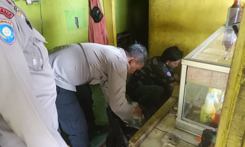 Seorang petugas kepolisian dari satuan Binmas melakukan pemeriksaan di sebuah kios