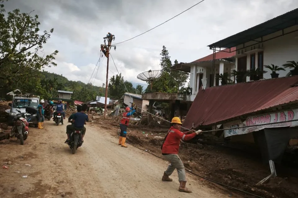 Petugas PLN melakukan penarikan kabel untuk disambungkan ke tiang-tiang listrik jaringan tegangan rendah (JTR) baru di Kabupaten Agam. Total lebih dari 600 tiang listrik pengganti berhasil dipasang oleh Petugas PLN guna memastikan suplai listrik kepada masyarakat kembali normal.