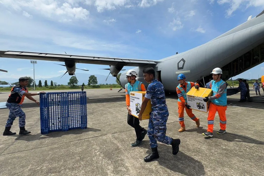 Tampak Personel PLN dan TNI Angkatan Udara bergotong royong memindahkan genset dan material tower darurat dari pesawat Hercules yang baru saja mendarat di Landasan Udara Sultan Iskandar Muda, Aceh. Material tersebut dikirim secara bertahap dari Landasan Udara Halim Perdanakusuma, Jakarta.