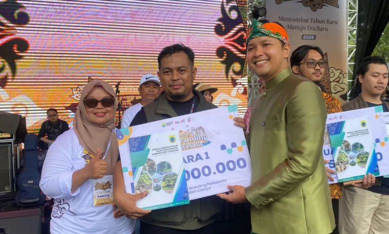 Bupati Cianjur (kanan) didampingi Kabid Pemasaran Pariwisata Disbudpar Cianjur, Tita Rosilawati (kiri), menyerahkan penghargaan secara simbolis kepada Yayan Sopyan (tengah) sebagai Juara 1 Sayembara City Branding Pariwisata Kabupaten Cianjur dalam acara Karnaval Lengkah Ka Jaman Anyar, Jumat (20/12/2025).