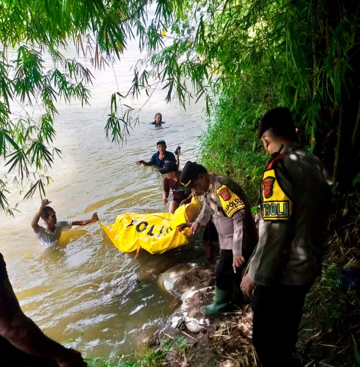 Personel Polsek Sindangbarang dibantu warga mengevakuasi jenazah Apid (64) dari Sungai Cisadea di Kampung Pasalakan, Desa Sirnagalih, Sindangbarang, Cianjur, Kamis (25/12/2025).