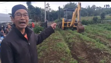 Tokoh masyarakat Pasir Cina Girang, Aryo Prima, menunjuk alat berat proyek geothermal yang masuk ke zona penolakan warga di Desa Cipendawa, Pacet, Minggu (11/1/2026).